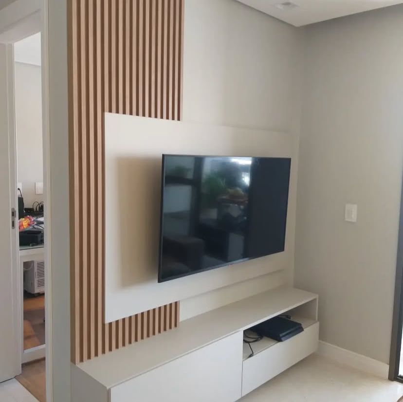 Sala de estar moderna com sofá cinza, mesa de centro de madeira e decoração minimalista, criando um ambiente acolhedor e elegante.